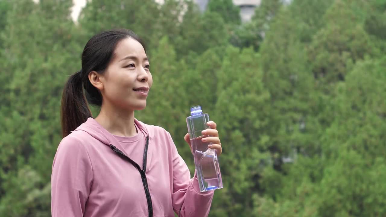 亚洲中国人女性在户外森林大自然喝水饮用水视频素材