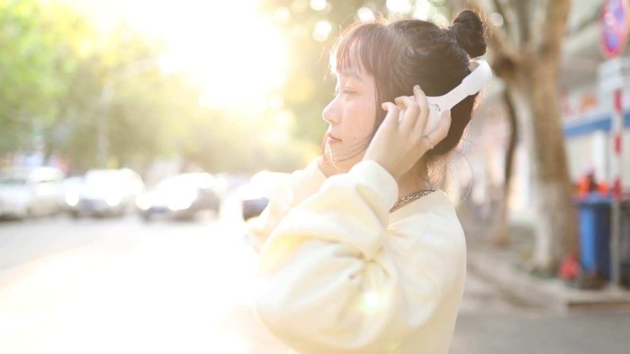 亚洲青年女性带耳机逆光肖像视频素材