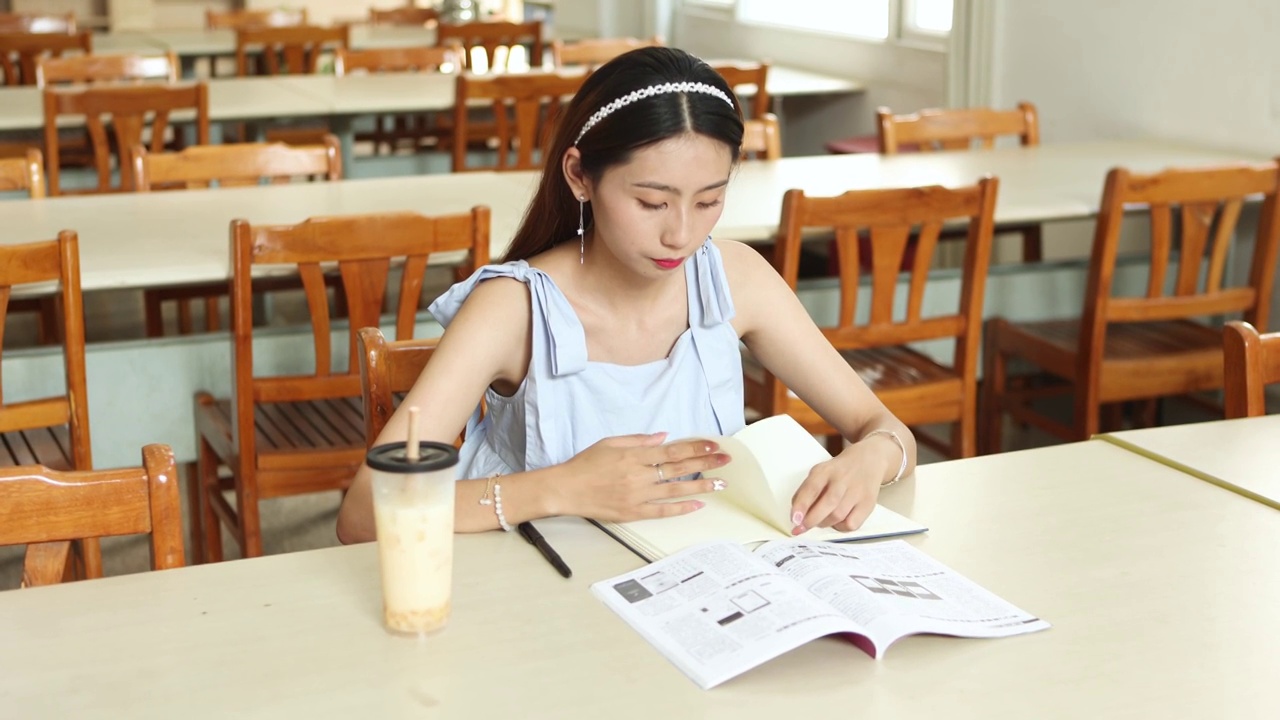 一个亚洲美女大学生在图书馆自习室里学习视频素材