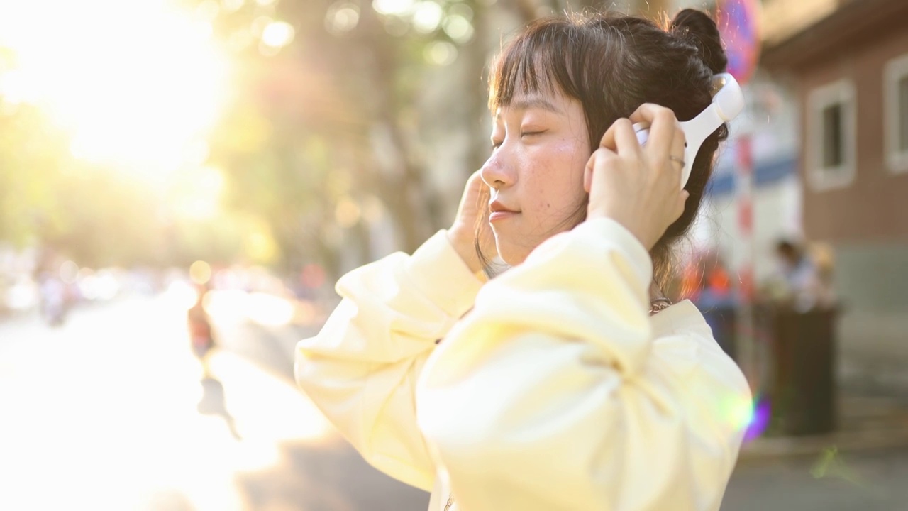 亚洲青年女性带耳机逆光肖像视频素材