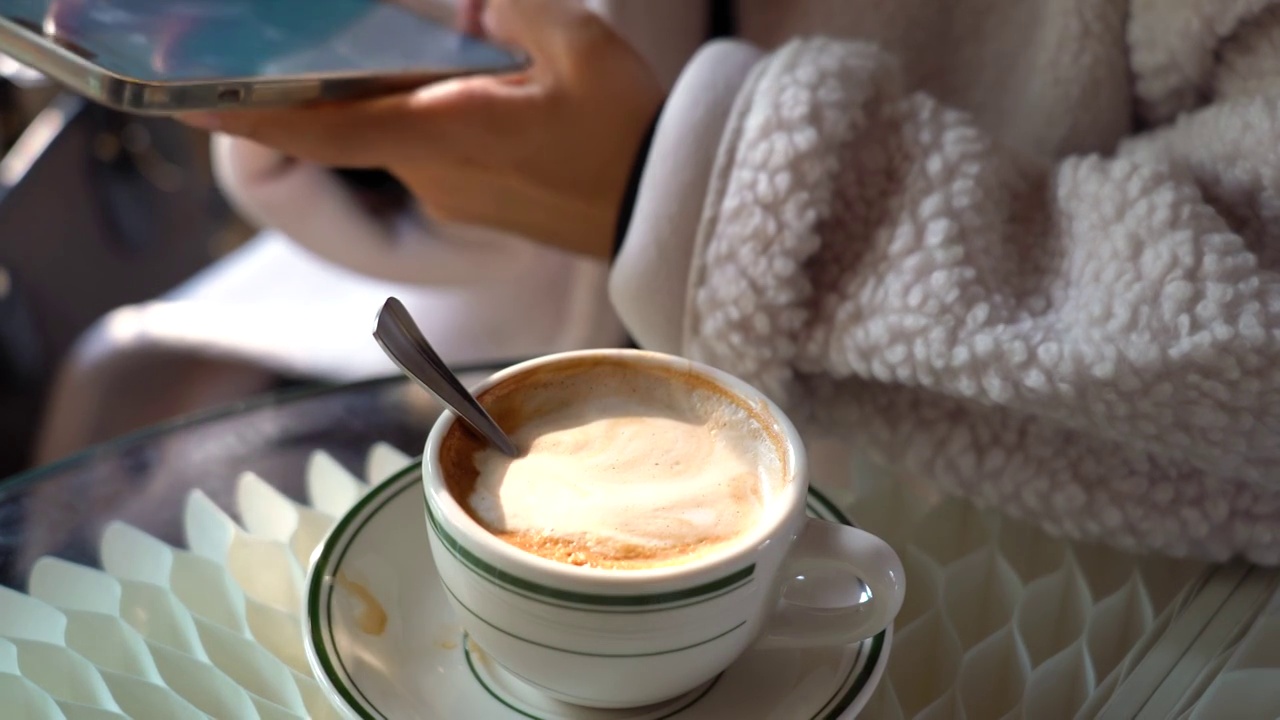 亚洲面孔中国女性在咖啡馆喝咖啡玩手机视频购买
