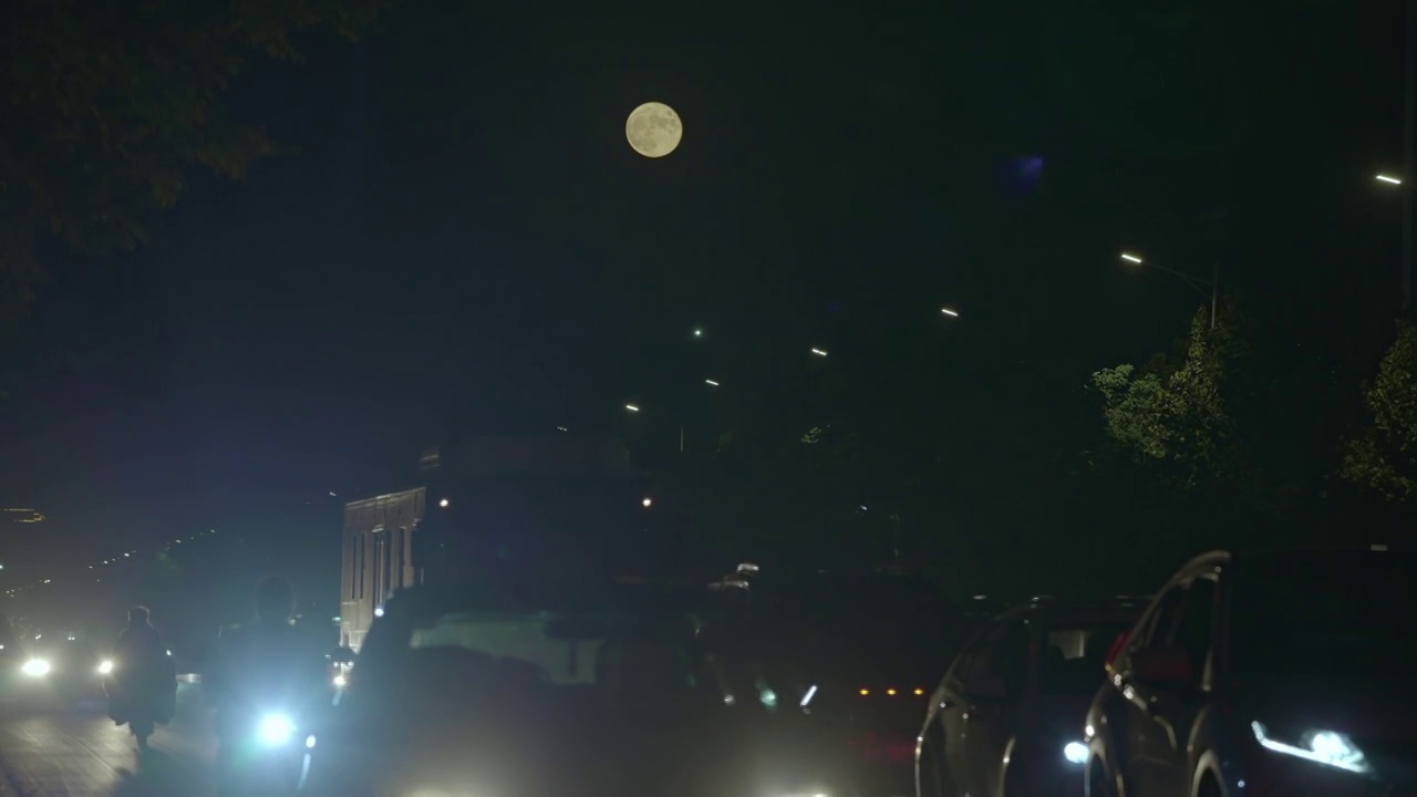 城市夜晚车流月亮慢慢升起视频素材