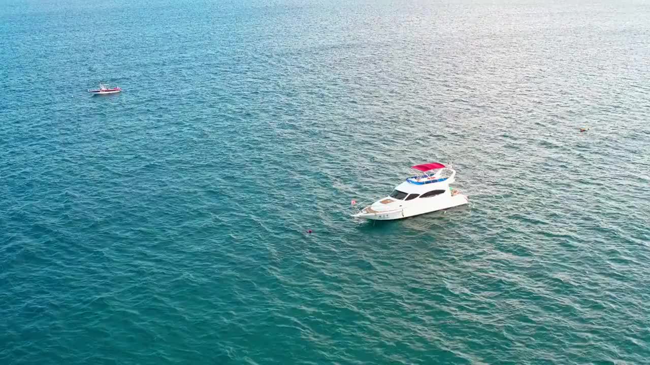 海南省三亚市亚龙湾一艘观光船游艇行驶在海平面上视频素材