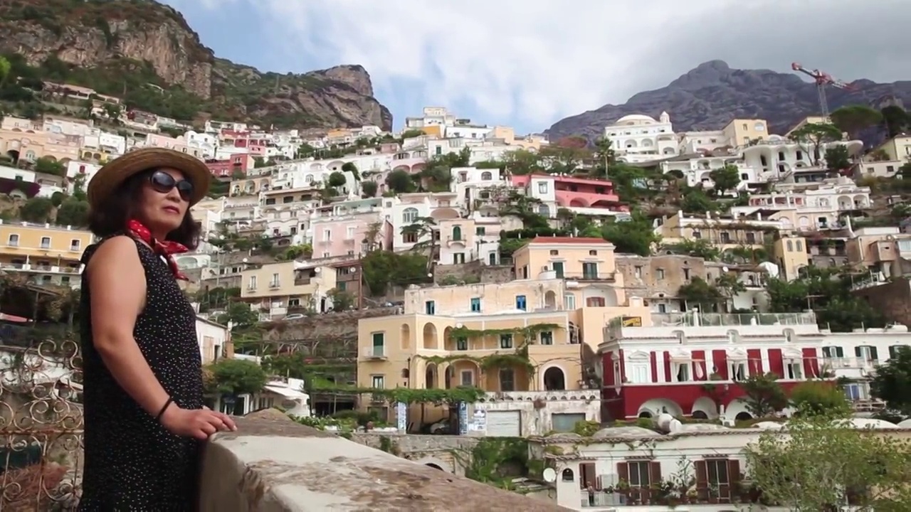 在意大利波西塔诺山上欣赏小镇风景的女人视频素材