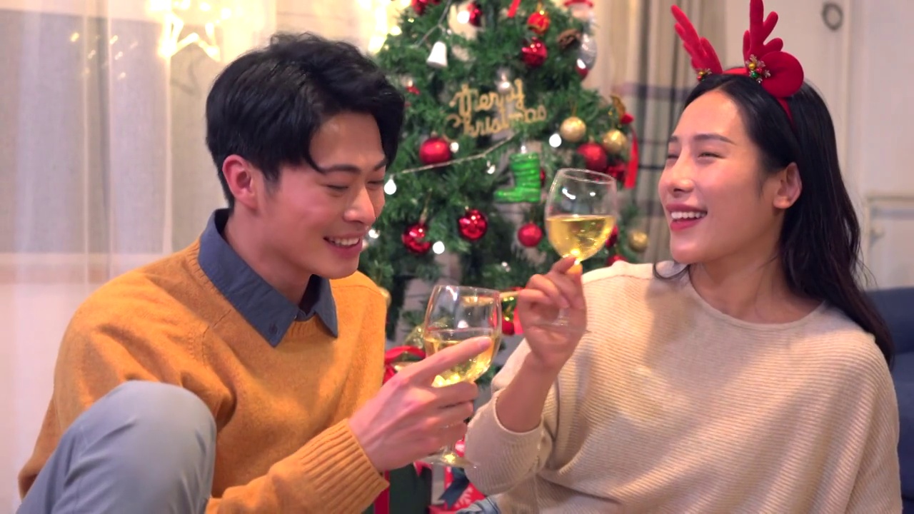 年轻情侣圣诞节在家喝酒庆祝视频素材