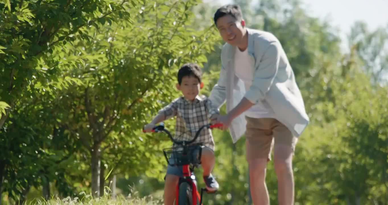 父亲教儿子骑自行车视频素材
