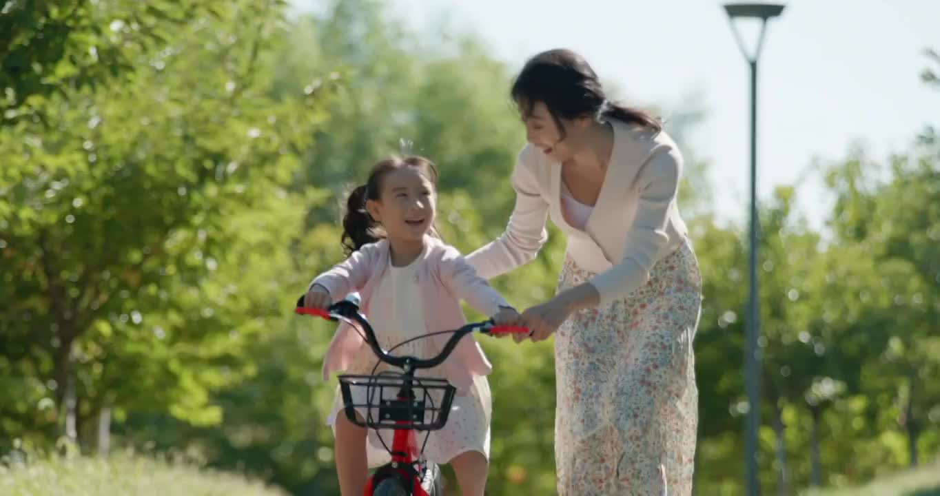 母亲教女儿骑自行车视频素材