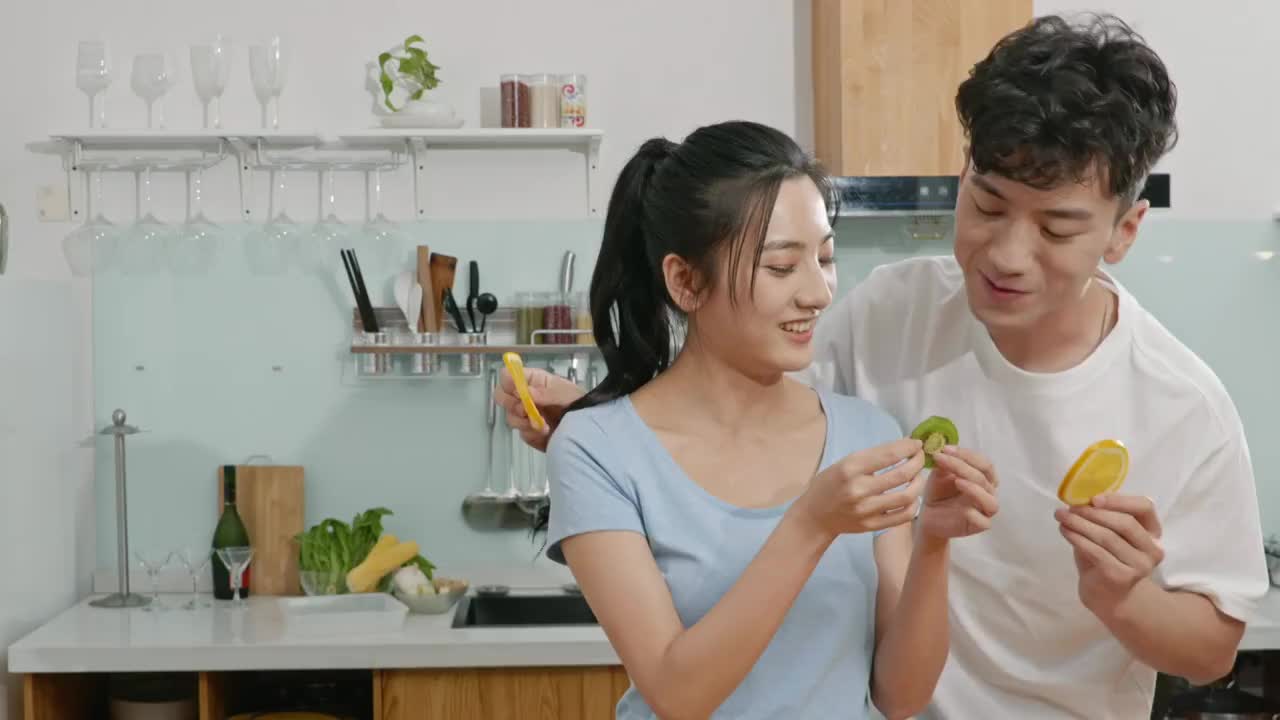 快乐的年轻夫妇在厨房吃水果视频素材
