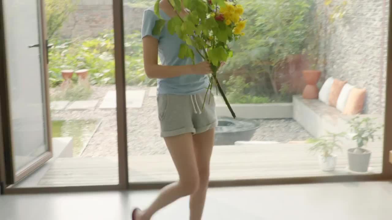 年轻女子用鲜花装饰家里视频素材
