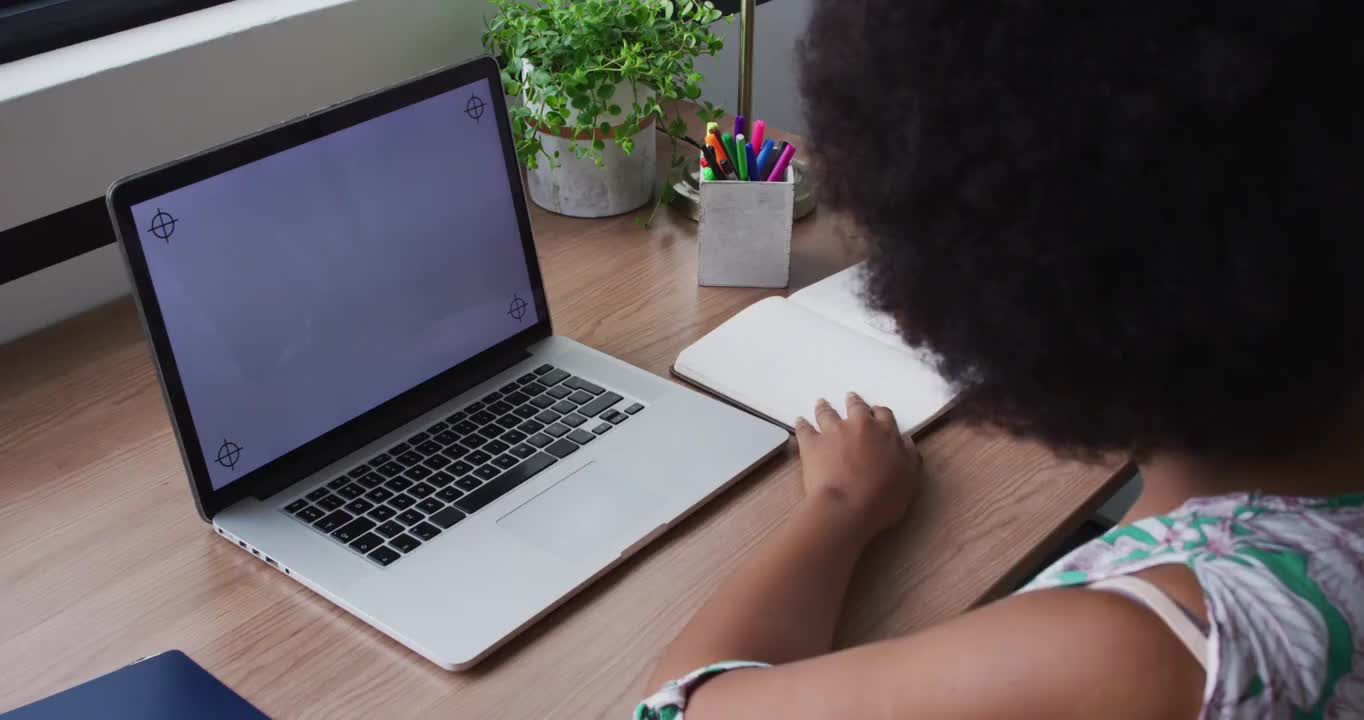 非裔美国商人在视频电话，记笔记，使用笔记本电脑与复制空间在屏幕上视频下载