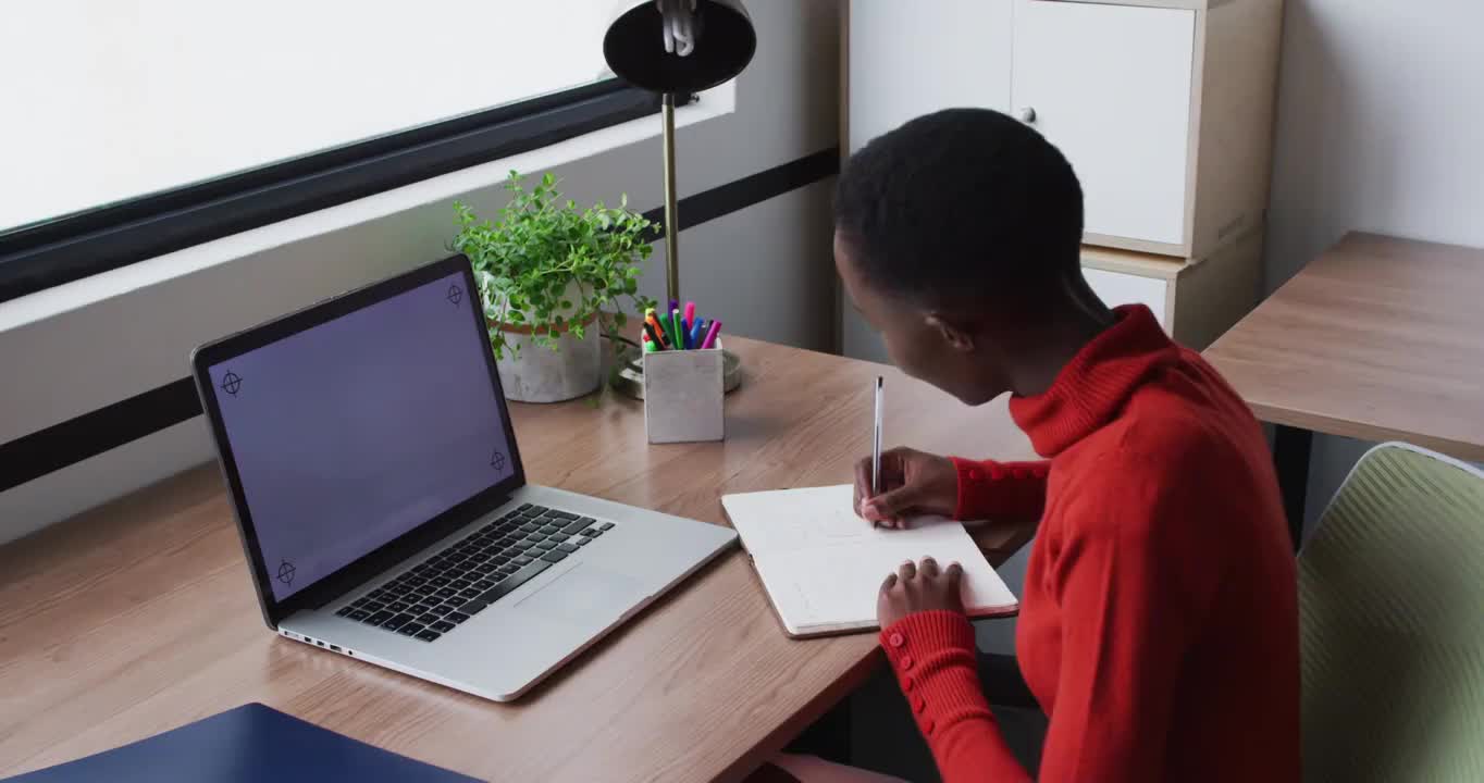 非裔美国商人写和微笑，在视频通话使用笔记本电脑，复制空间在屏幕上视频下载