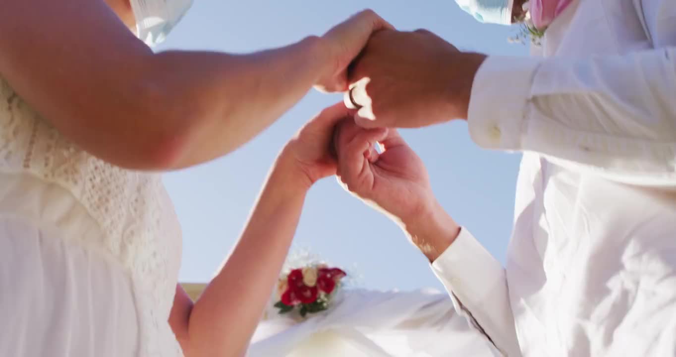 幸福的白人新婚夫妇戴着面具在圣坛前触碰头的肖像视频下载