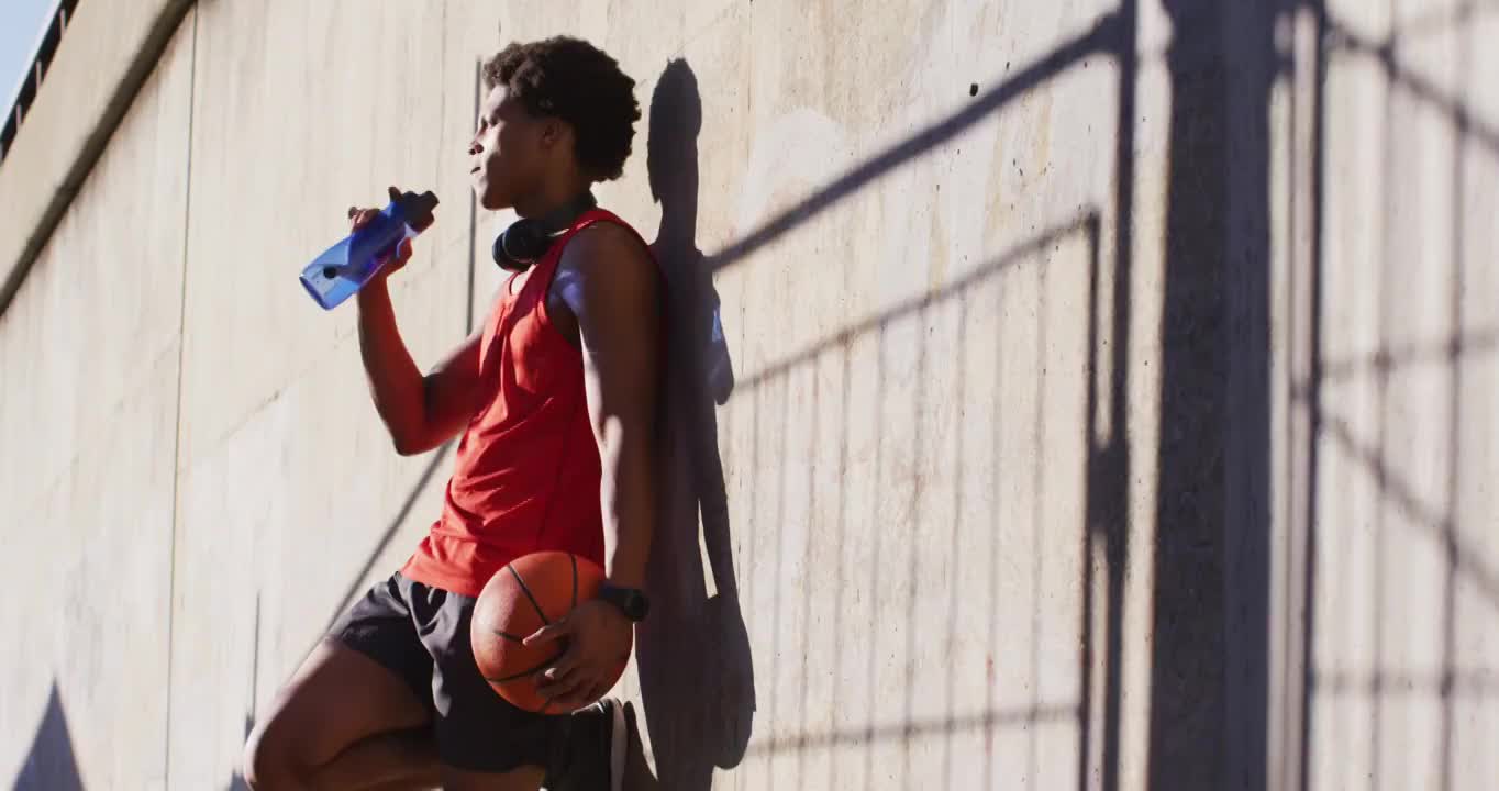 健康的非洲裔美国人在城市运动，休息，喝水，打篮球视频素材