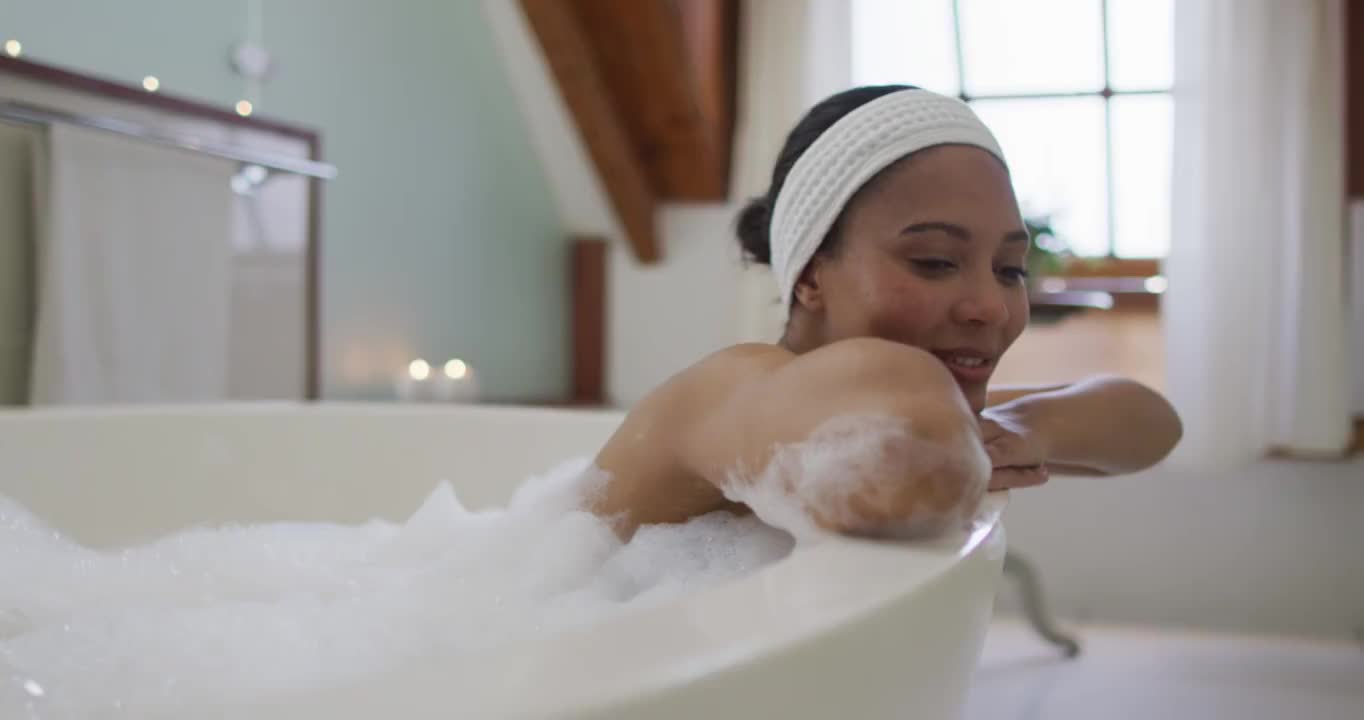混血儿妇女的肖像洗澡看着相机和微笑视频下载
