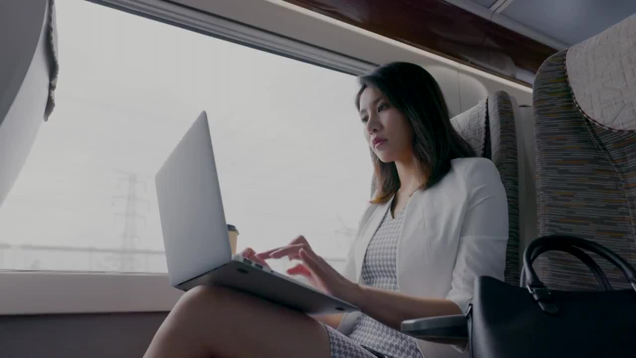 年轻商务女士在高铁上使用笔记本电脑视频素材
