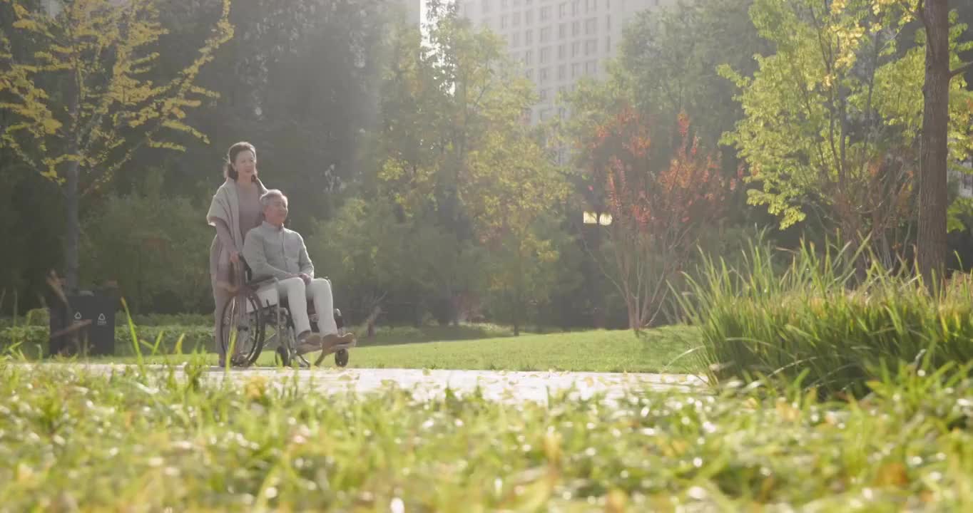 老人推着坐轮椅的老伴逛公园视频素材
