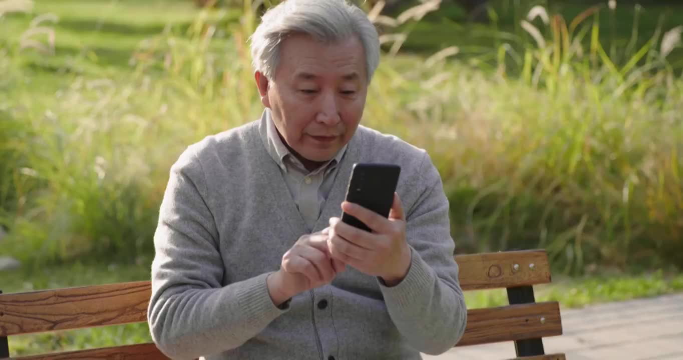 老年男子在公园使用手机视频素材