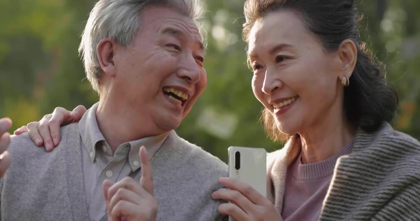 老年夫妇在公园使用手机视频素材