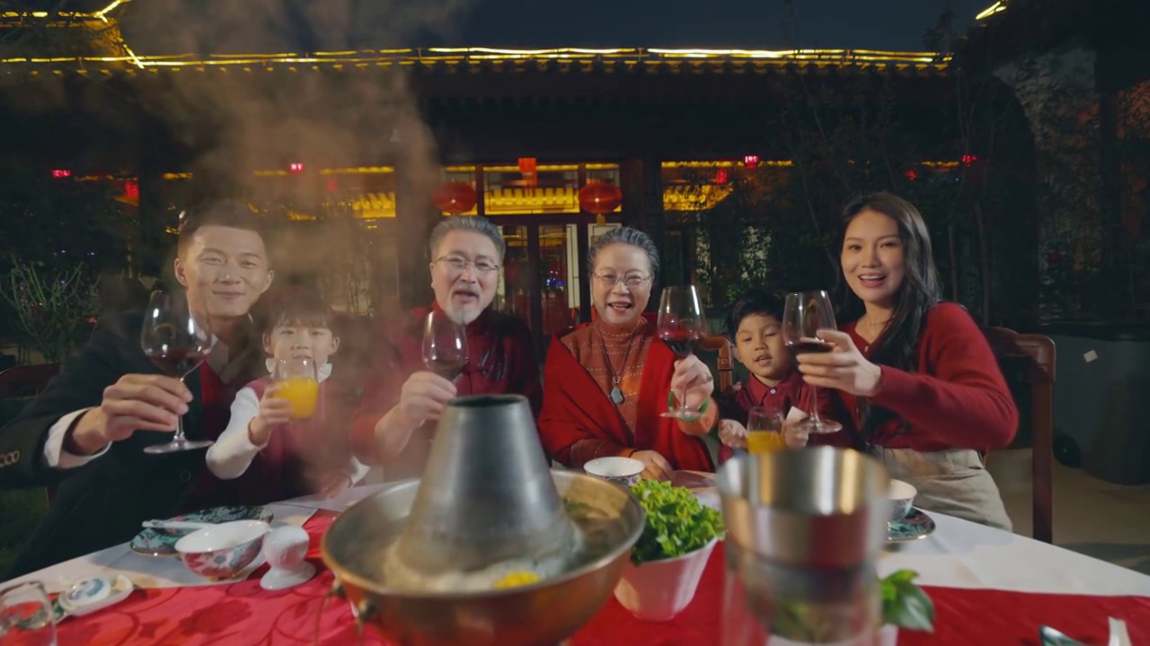 东方家庭在中式庭院内举杯庆祝新年视频下载