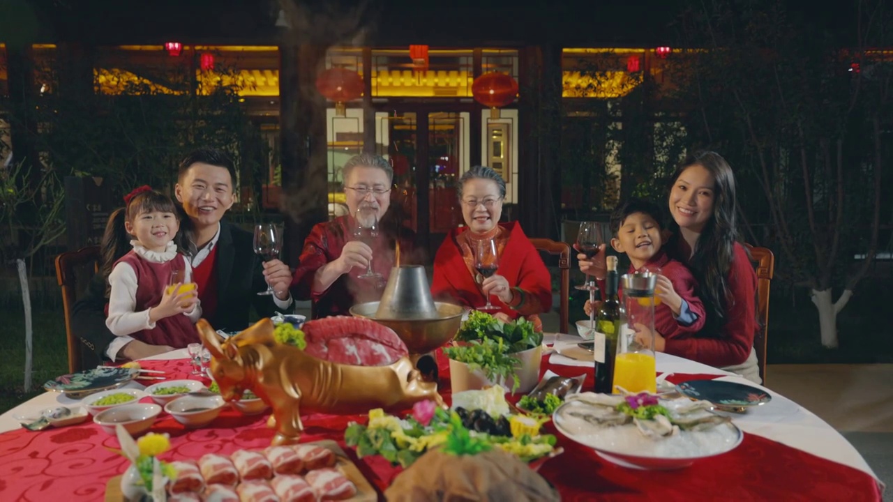 东方家庭在中式庭院内干杯庆祝新年视频下载