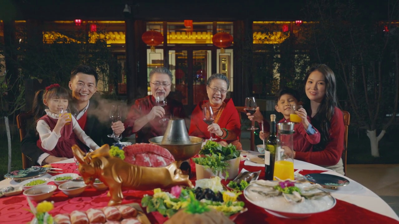 东方家庭在中式庭院内干杯庆祝新年视频下载
