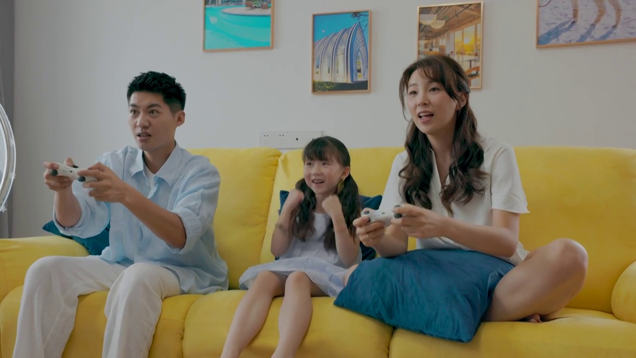 快乐家庭坐在沙发上玩游戏视频素材