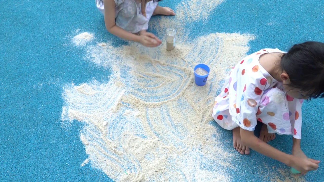 在户外地面上玩沙子的小女孩视频素材
