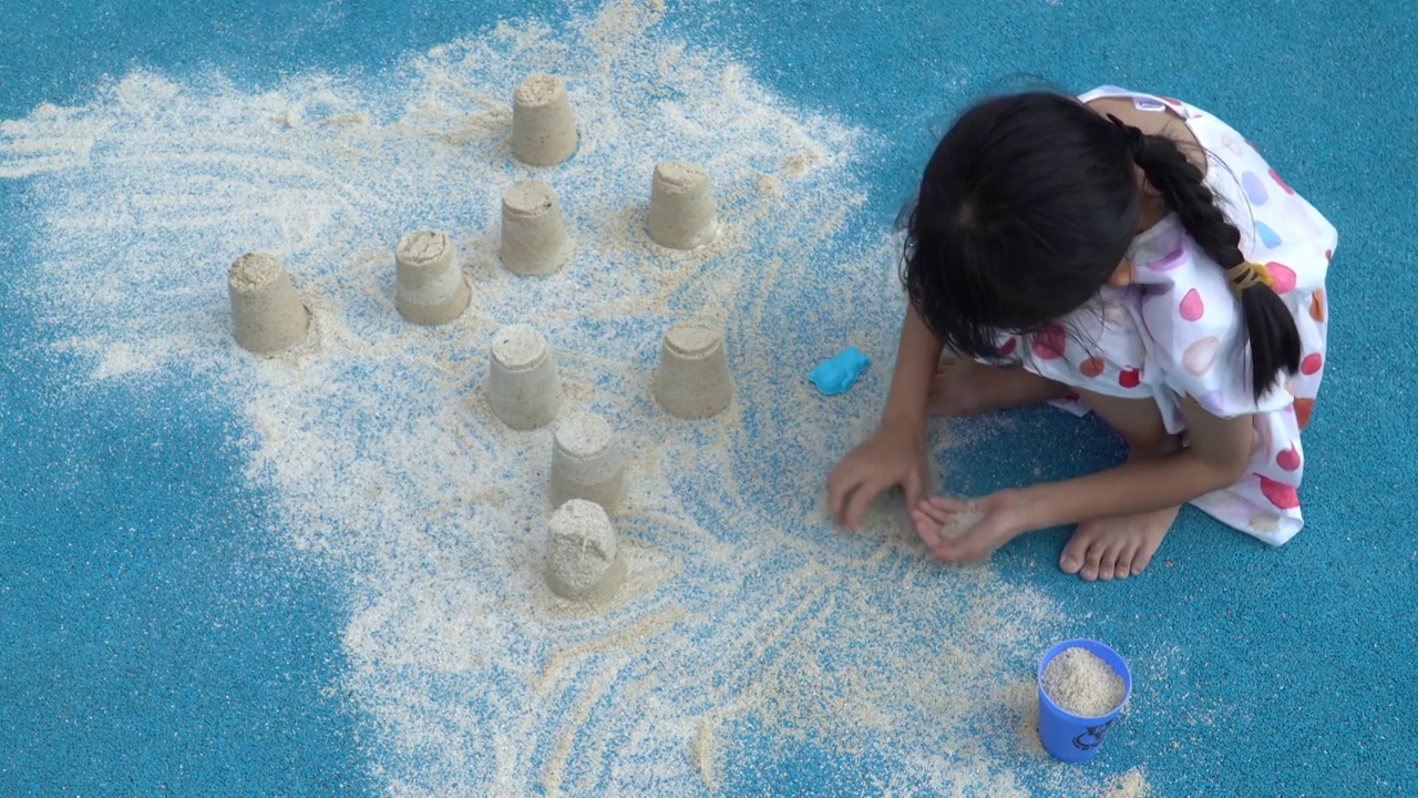 在户外地面上玩沙子的小女孩视频素材