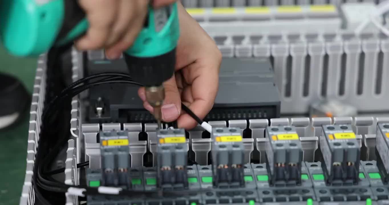工人使用电动螺丝刀固定压制电缆于继电器底座端子上视频素材