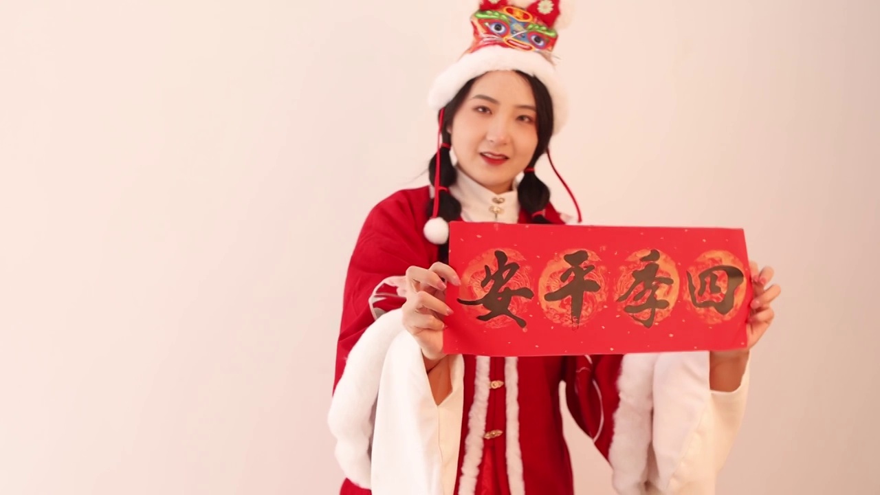穿着汉服带着虎头帽的亚洲美女拿着新年对联祝福视频素材
