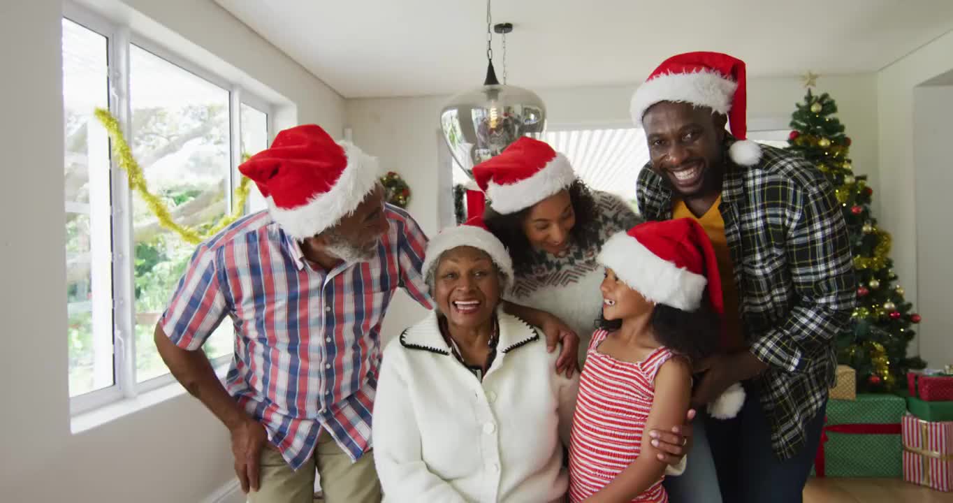 快乐的非裔美国人多代家庭戴着圣诞帽，拍摄节日照片视频下载