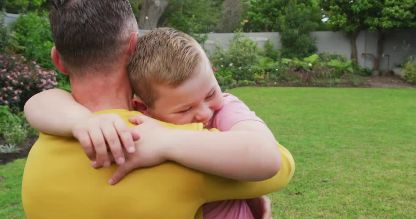 快乐的白人父亲带着儿子在花园里拥抱和搬运视频素材