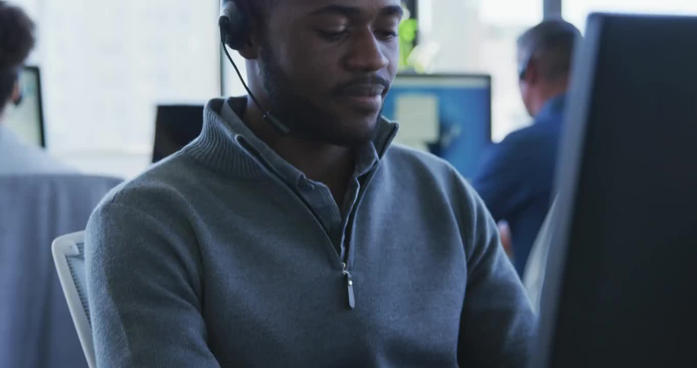 戴着耳机的年轻人在电脑上工作视频素材