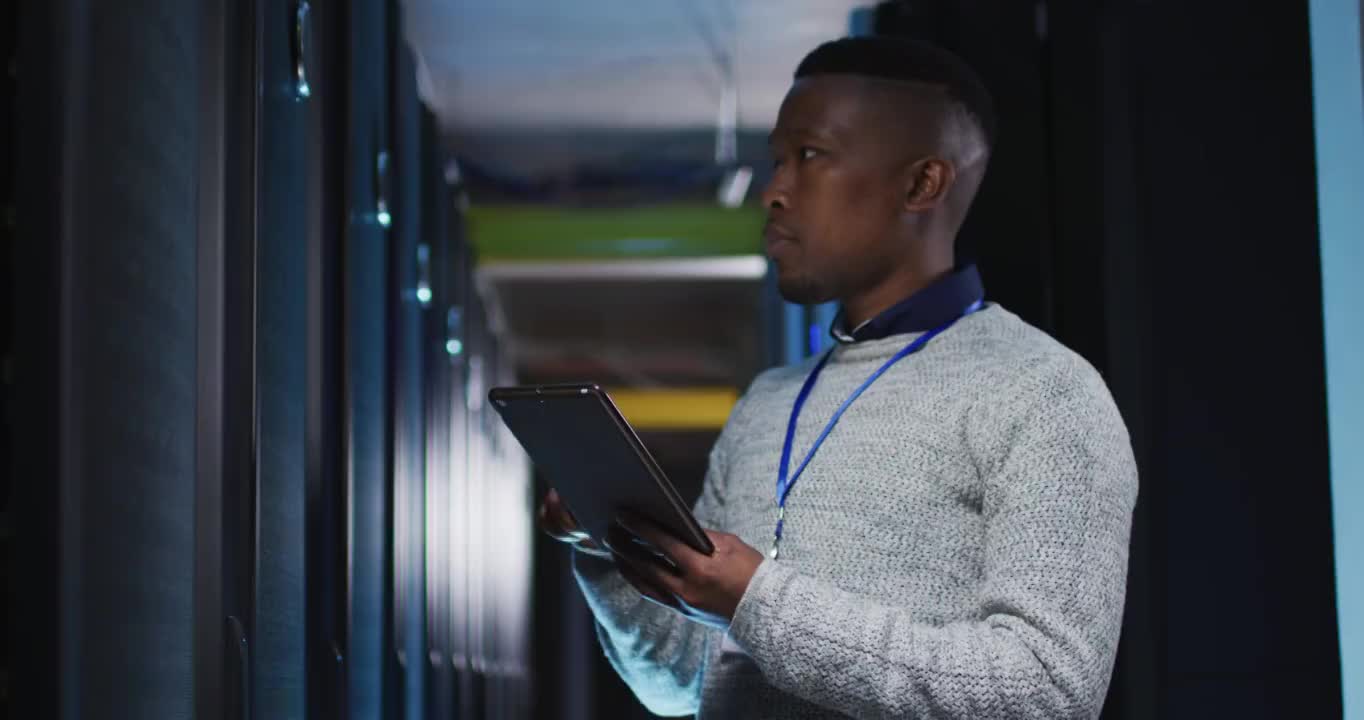 非裔美国男性计算机技术人员使用平板电脑在企业服务器室工作视频素材