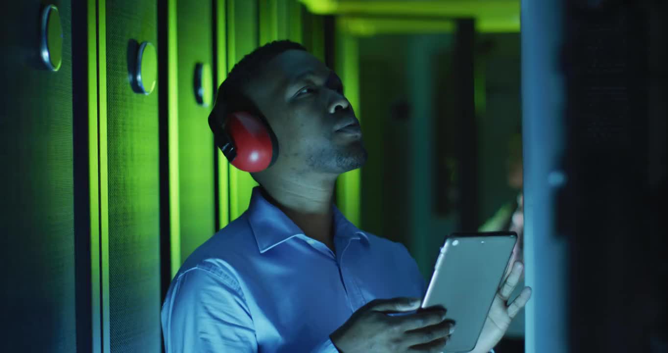 非裔美国男性计算机技术人员使用平板电脑在企业服务器室工作视频素材