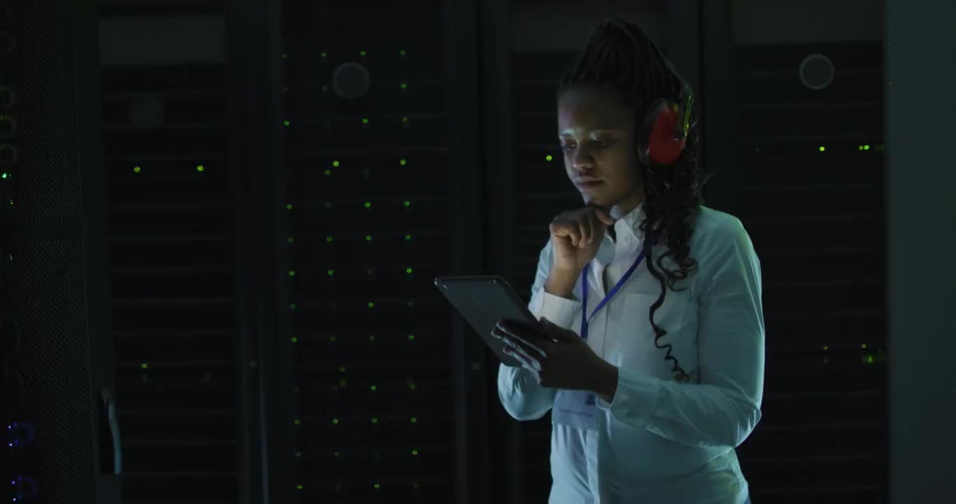 非裔美国女性计算机技术人员使用平板电脑在企业服务器室工作视频素材