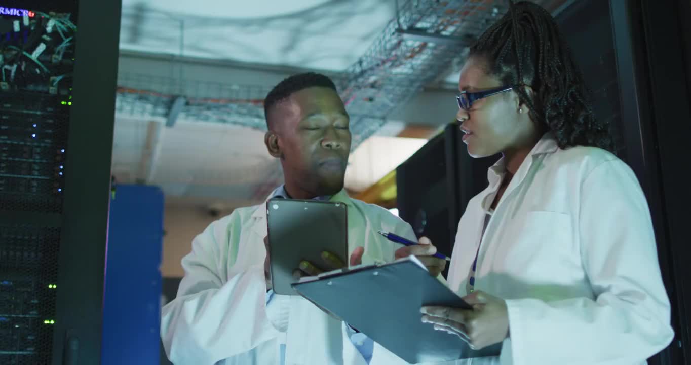 非裔美国人电脑技术人员使用平板电脑在企业服务器室工作视频素材