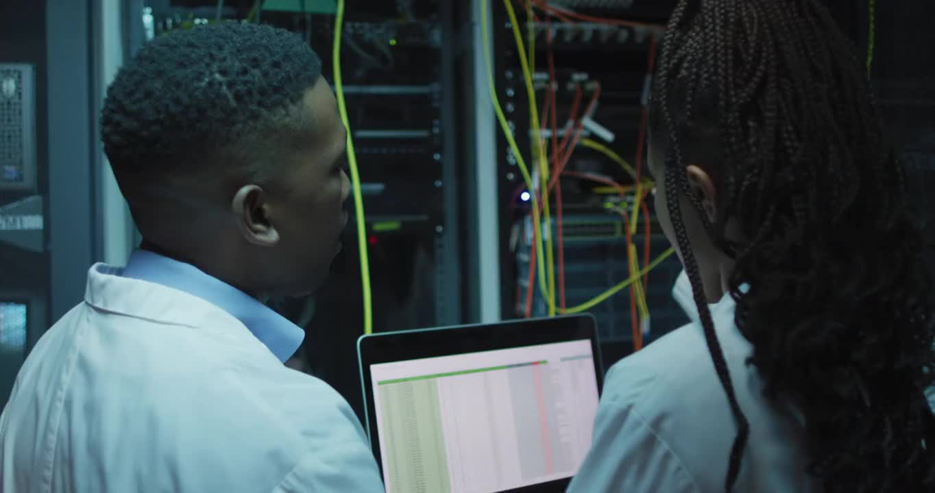 非裔美国人电脑技术人员使用平板电脑在企业服务器室工作视频素材