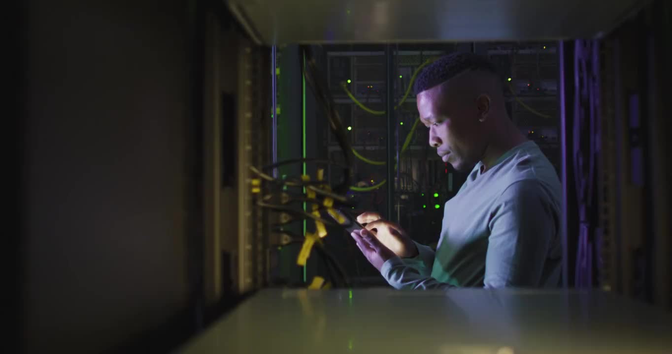 非裔美国男性计算机技术人员使用智能手机在企业服务器室工作视频下载
