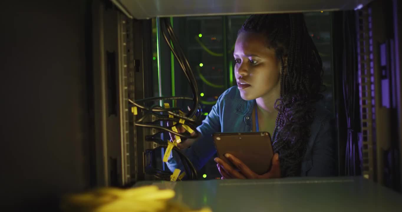 非裔美国女性计算机技术人员使用平板电脑在企业服务器室工作视频下载