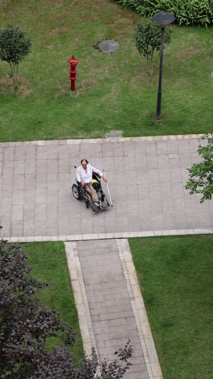 人像轮椅：患有小儿麻痹症的老年人坐着电动轮椅外出视频下载