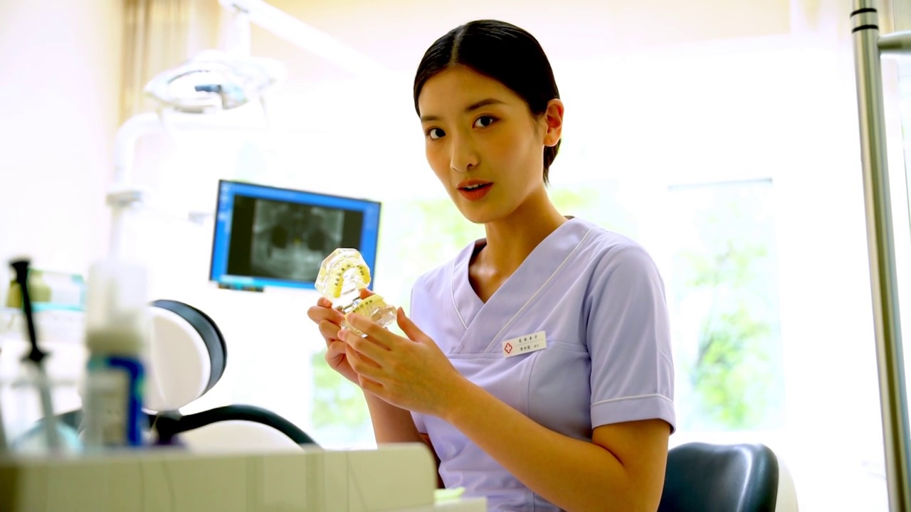 牙科门诊护士拿着牙齿模型视频下载