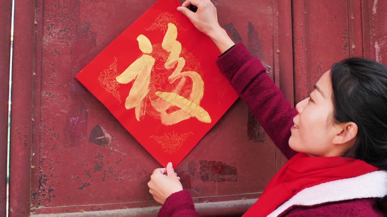 亚洲中国人女性女人过年贴春联贴福字欢度中国年新春视频素材