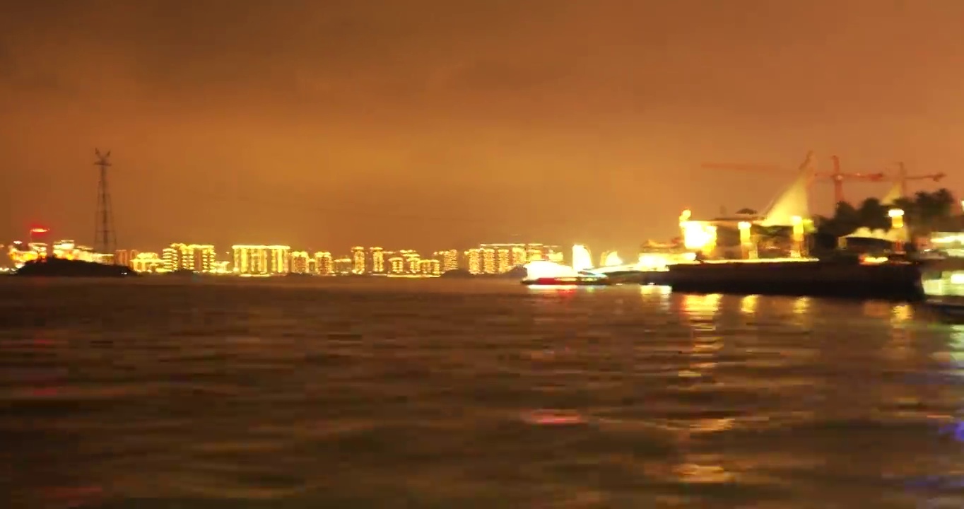 从中国福建厦门的海上看城市景色，灯光明亮，水面荡漾视频素材