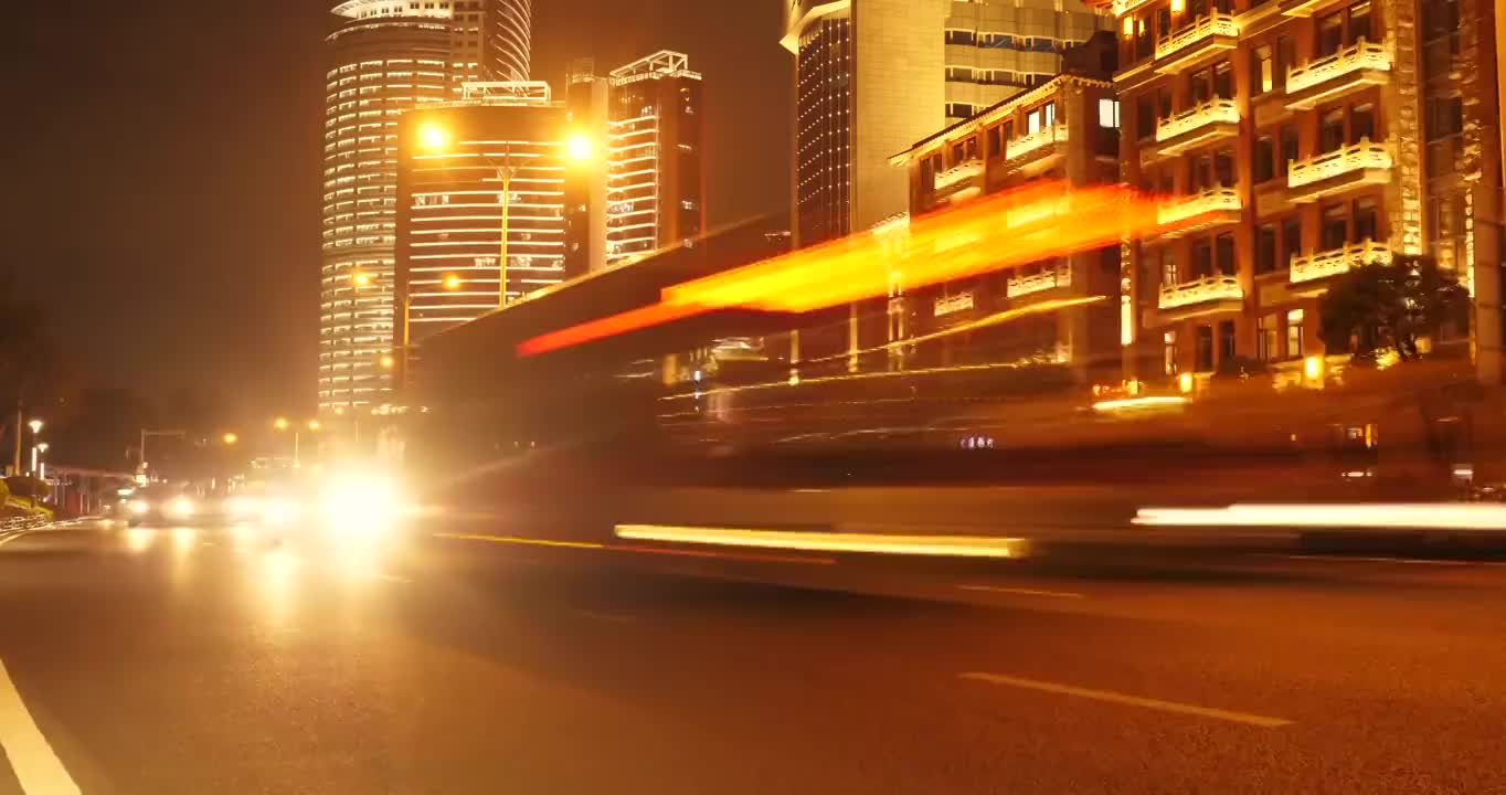 中国福建厦门的夜景，车辆穿梭在街道上，随着时间的推移，建筑物灯火通明视频素材