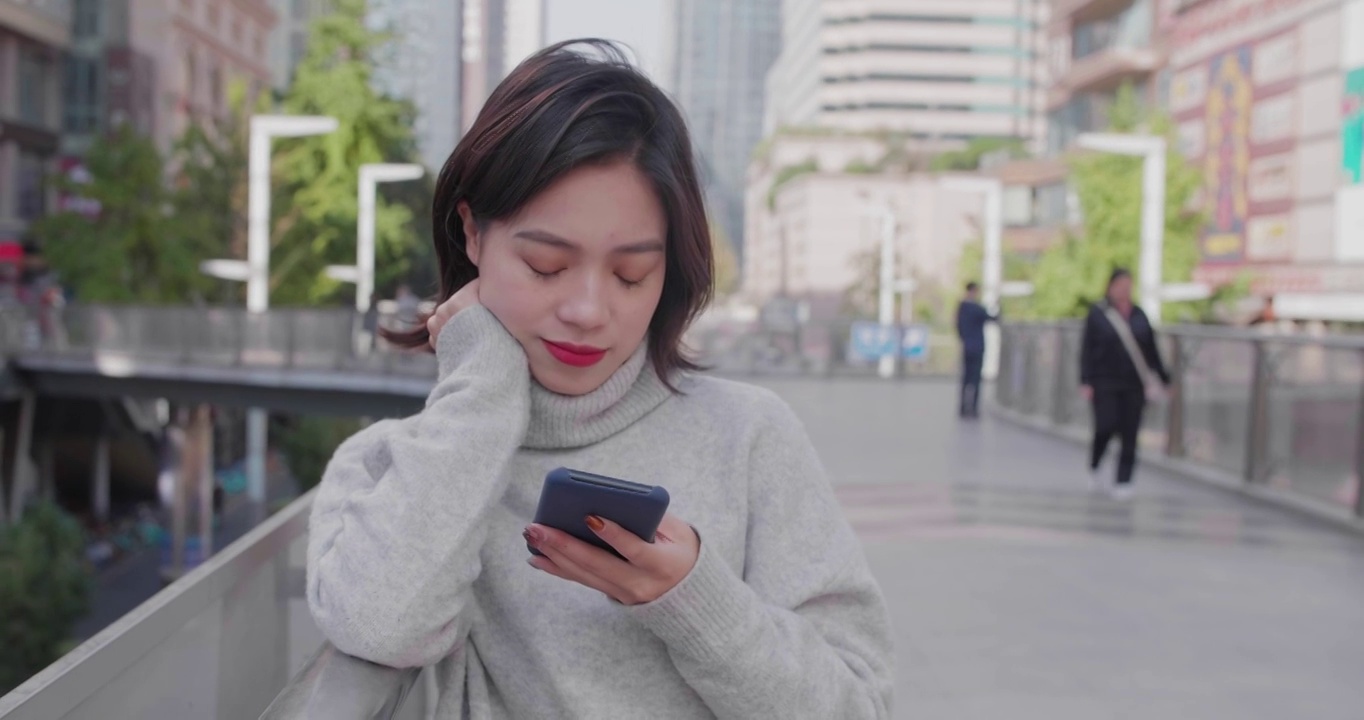 中国年轻女子在街上使用手机视频素材