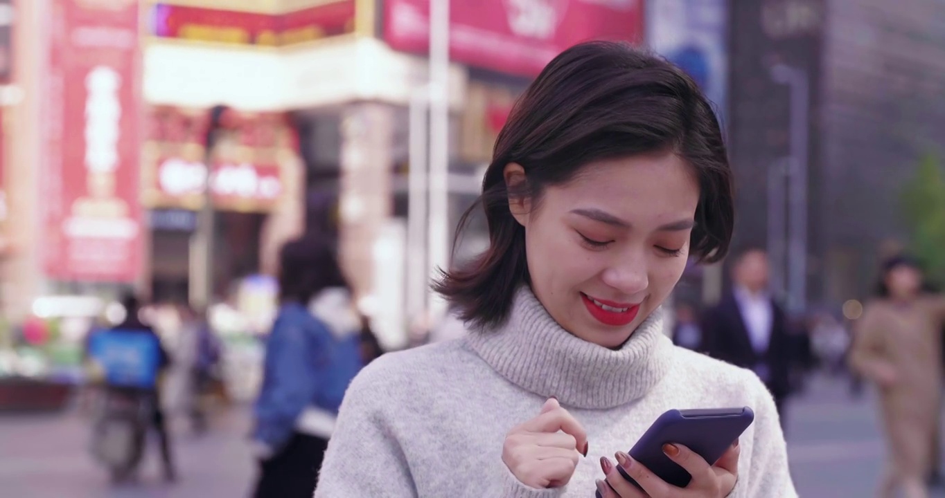 亚洲妇女在街上使用手机视频素材