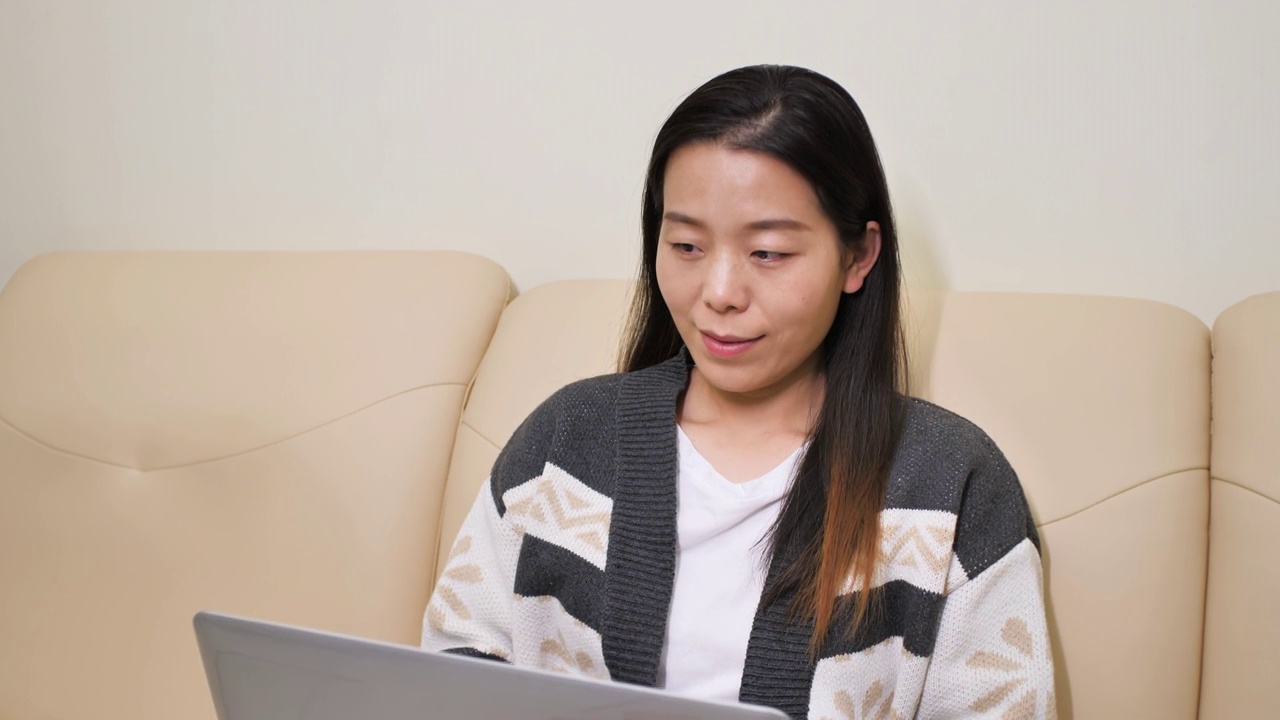 亚洲中国人女性女人居家坐沙发上办公玩手机上网购物视频素材
