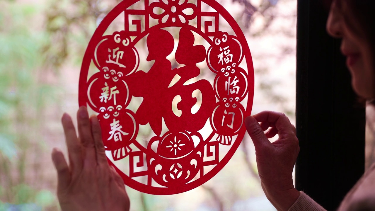 春节在家里贴窗花迎新年的中国女人视频素材
