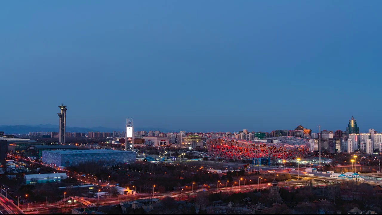 高角度拍摄北京冬奥场馆鸟巢钉子塔水立方日转夜延时视频素材